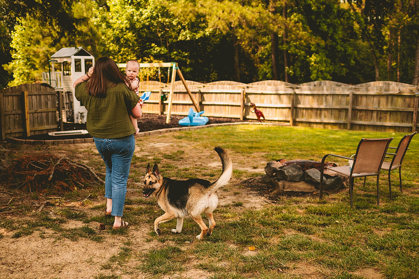 Mom carrying baby across backyard