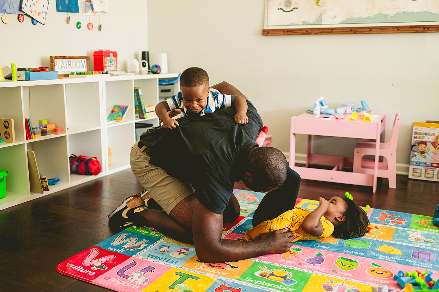 Dad wrestling with kids during family photos at home in Cary NC