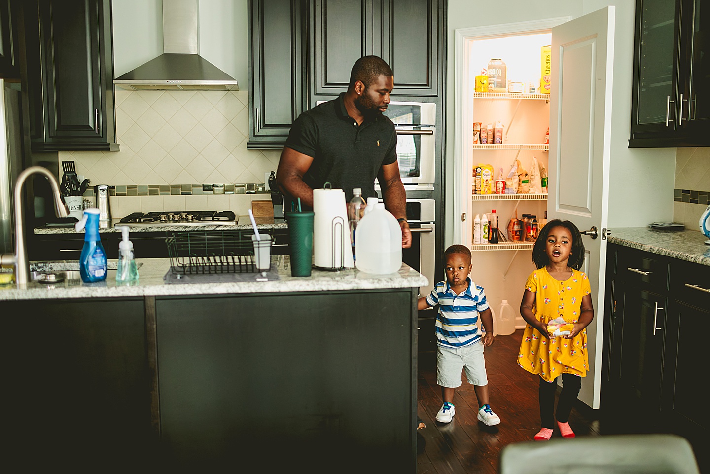 Dad helping kids get a snack in the kitchen