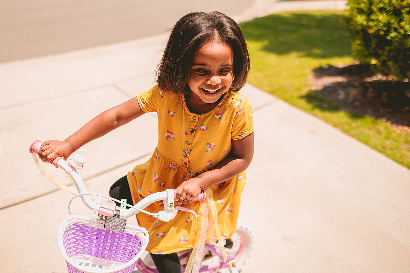 Kids riding bikes with their mom outside in the driveway