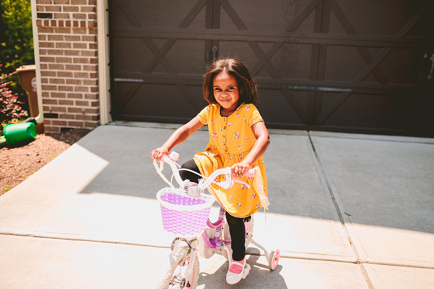 Kids riding bikes with their mom outside in the driveway