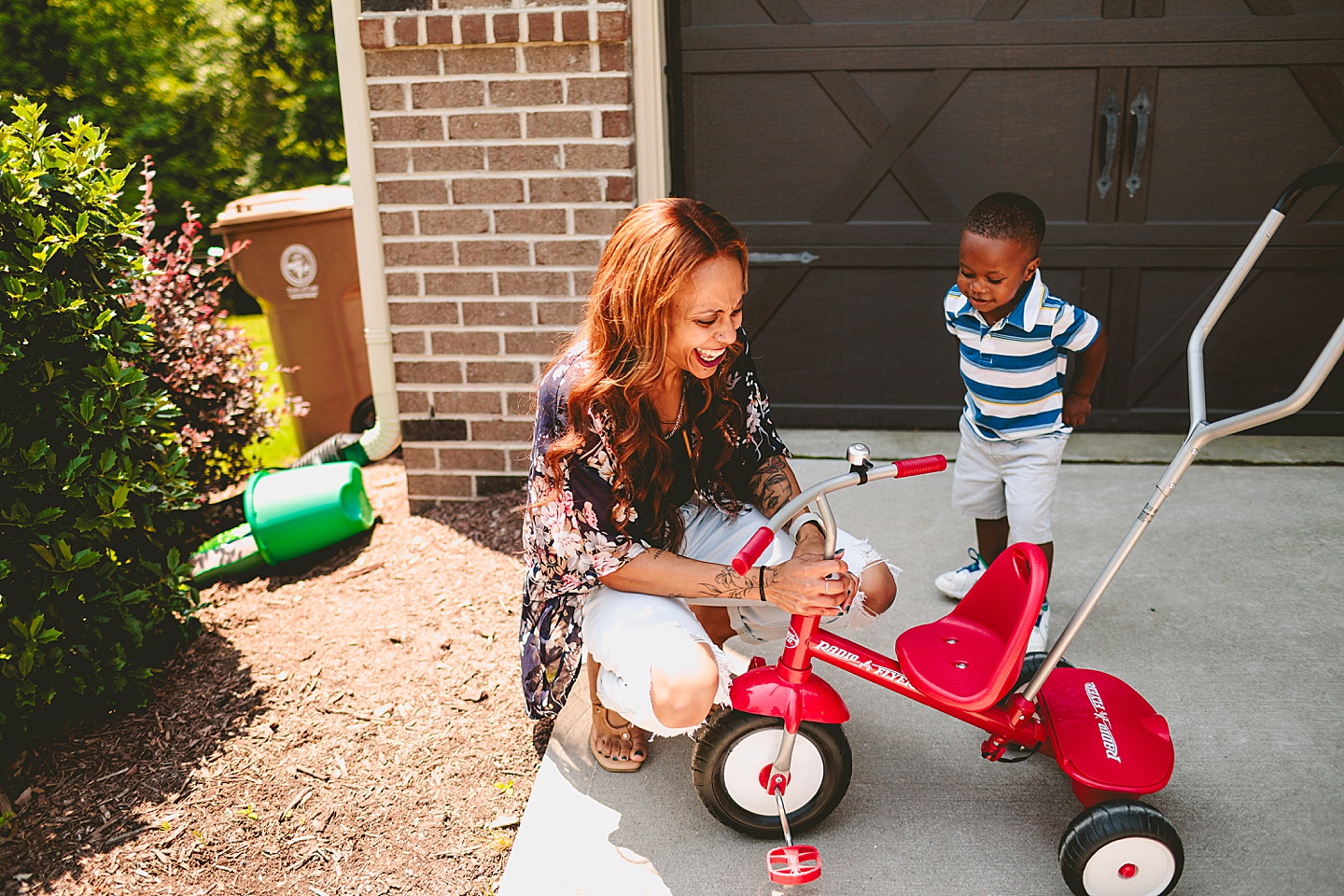 Kids riding bikes with their mom outside in the driveway