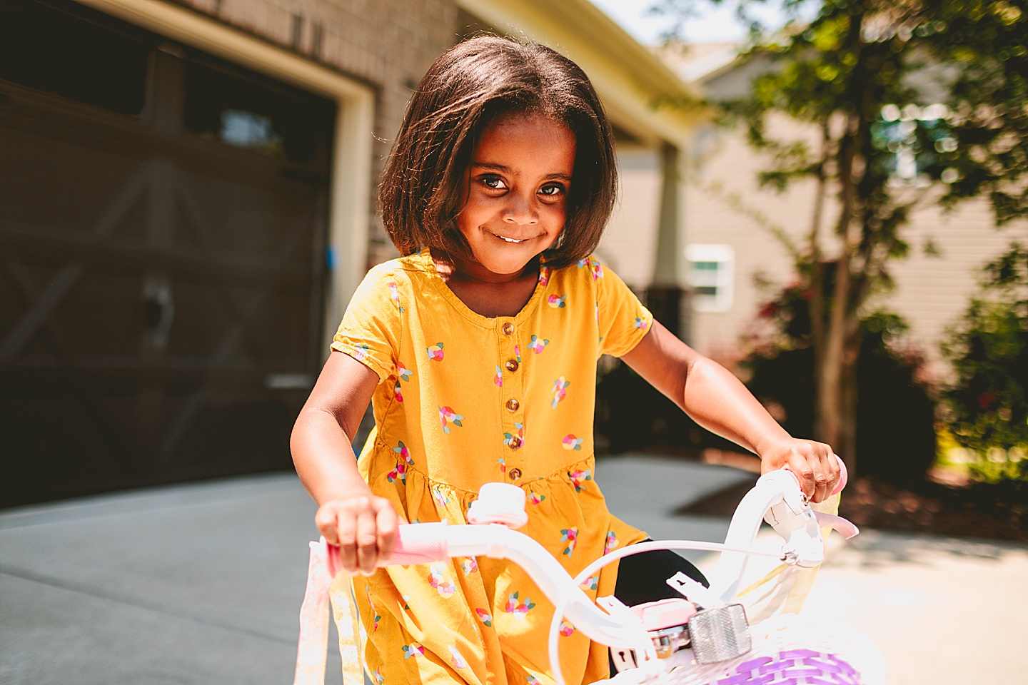 Kids riding bikes with their mom outside in the driveway