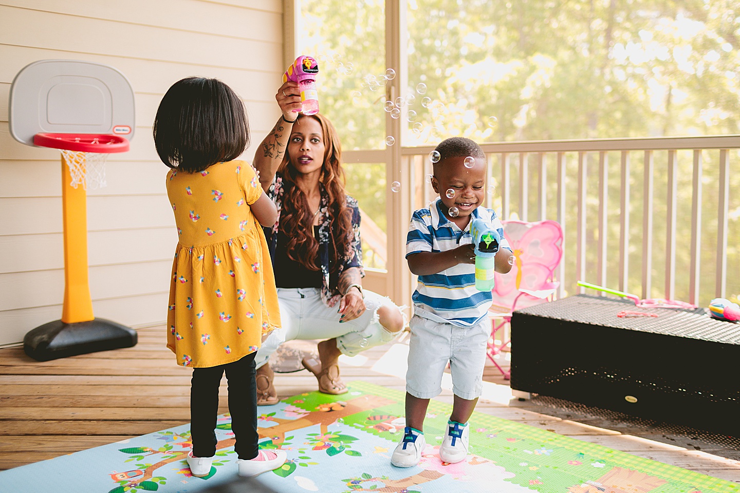 Kids running through bubbles outside on deck in Cary