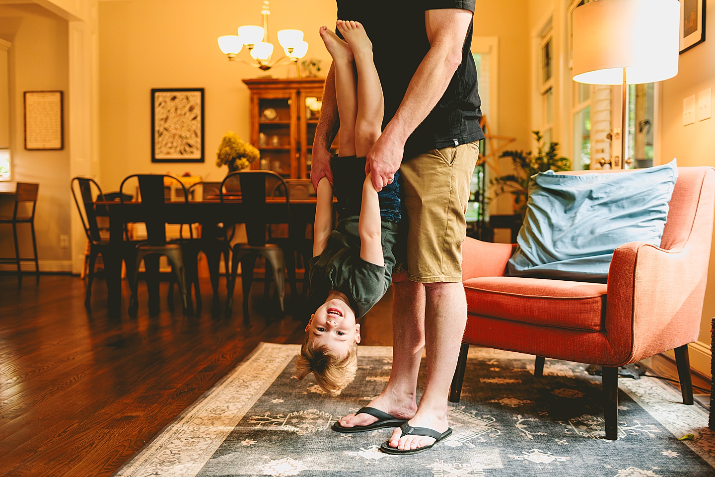 Kid playing with dad in living room during family photos