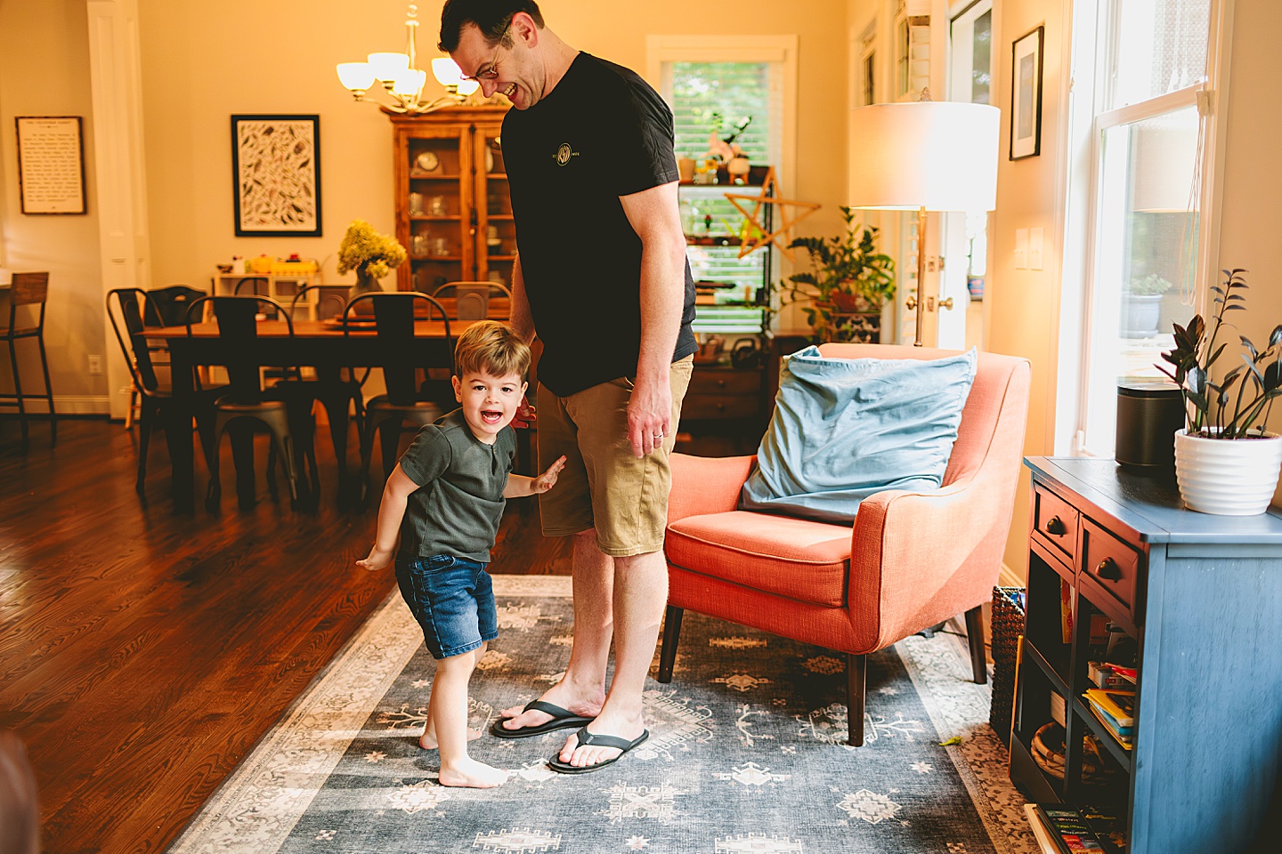 Kid playing with dad in living room during family photos