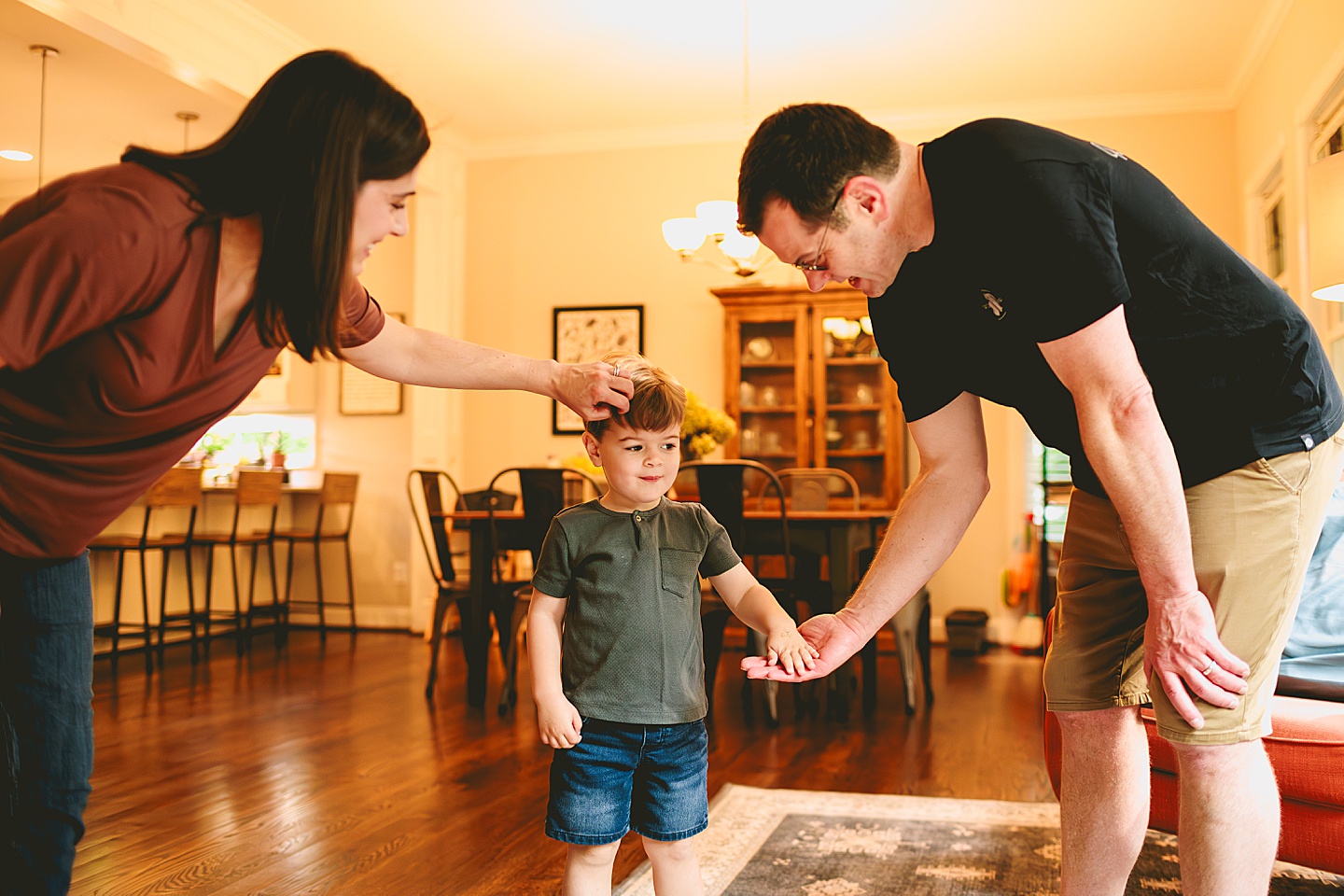 Kid playing with dad in living room during family photos