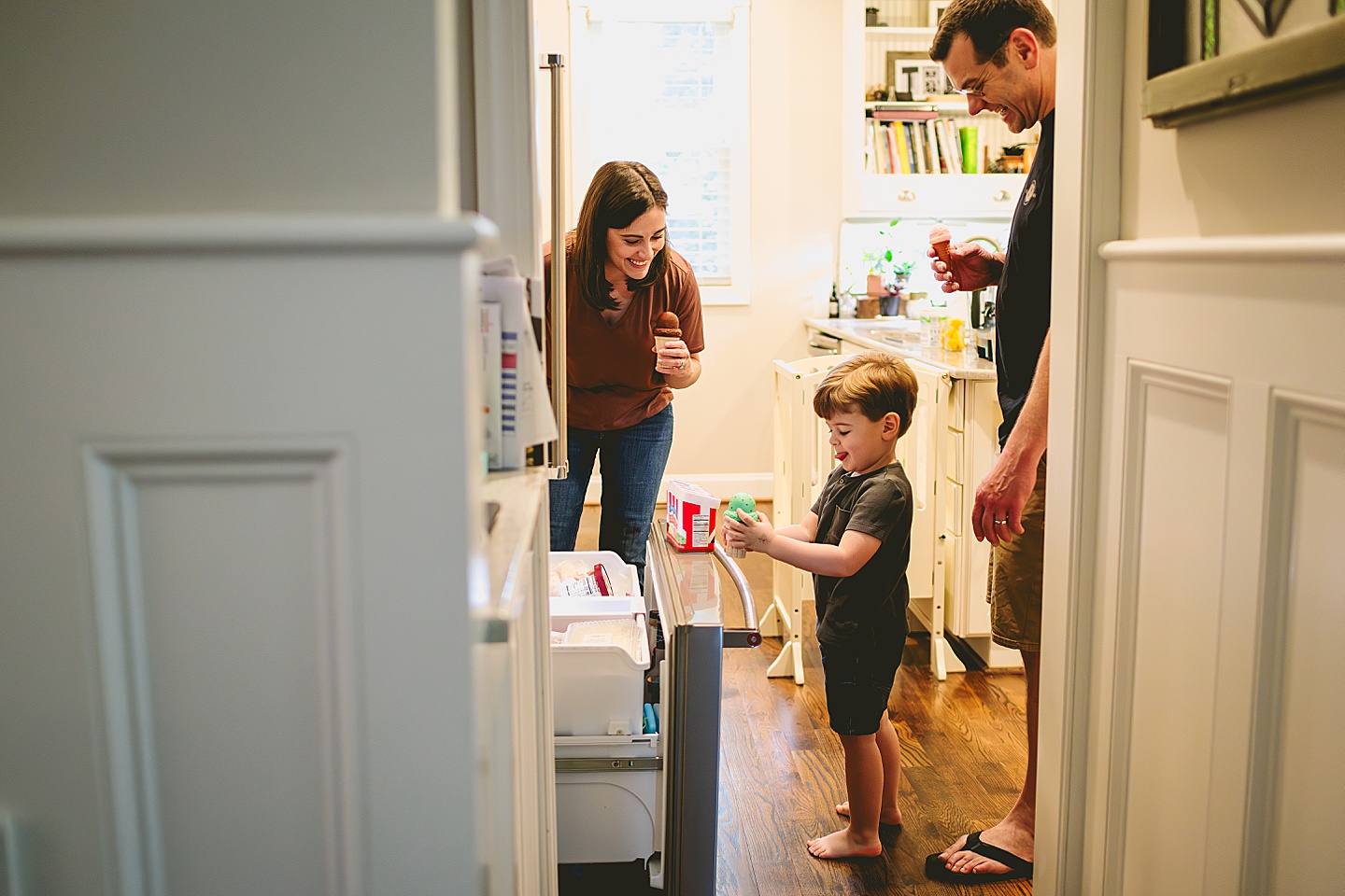 Toddler looking through the freezer for ice cream