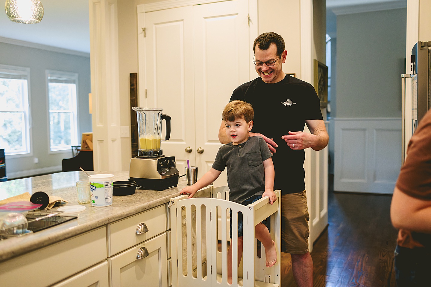 Kid making a smoothie with his parents in the kitchen