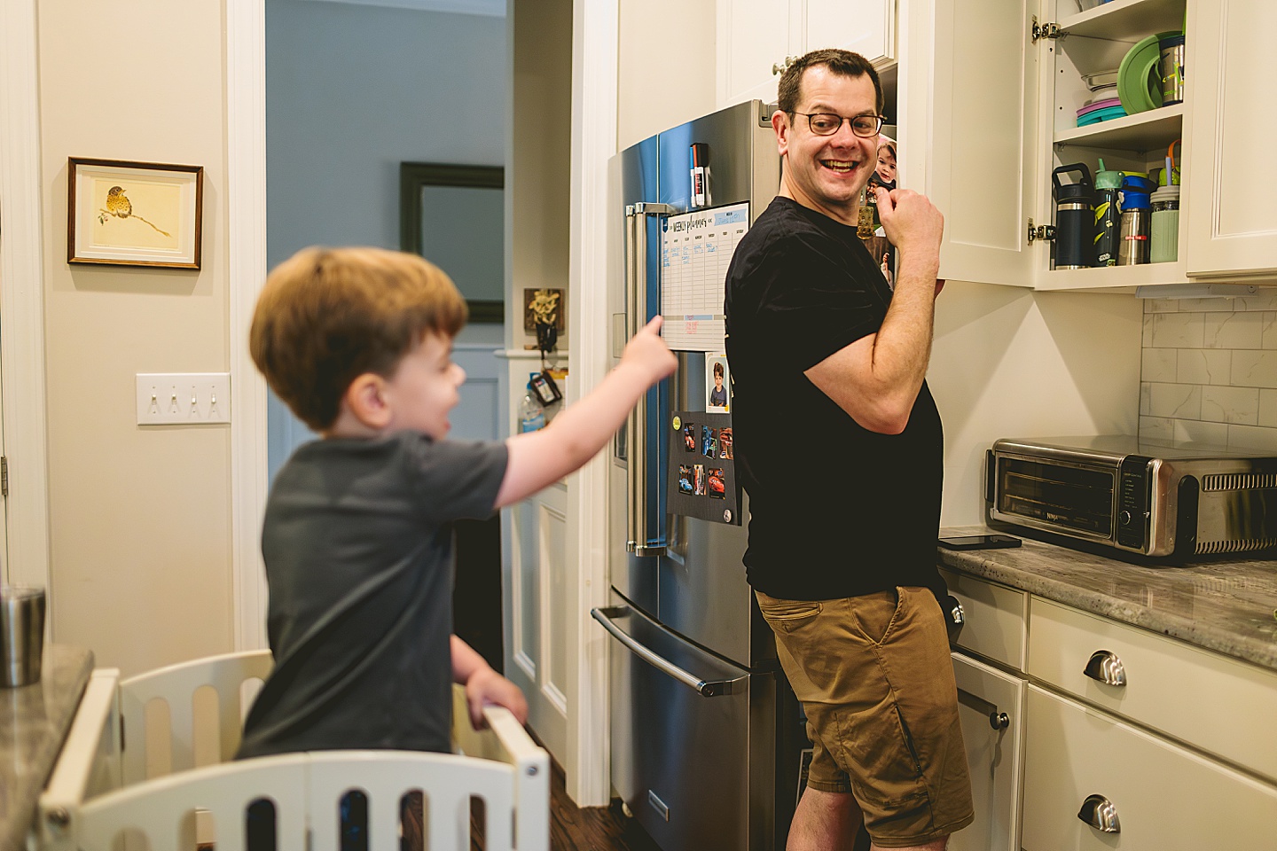 Kid making a smoothie with his parents in the kitchen