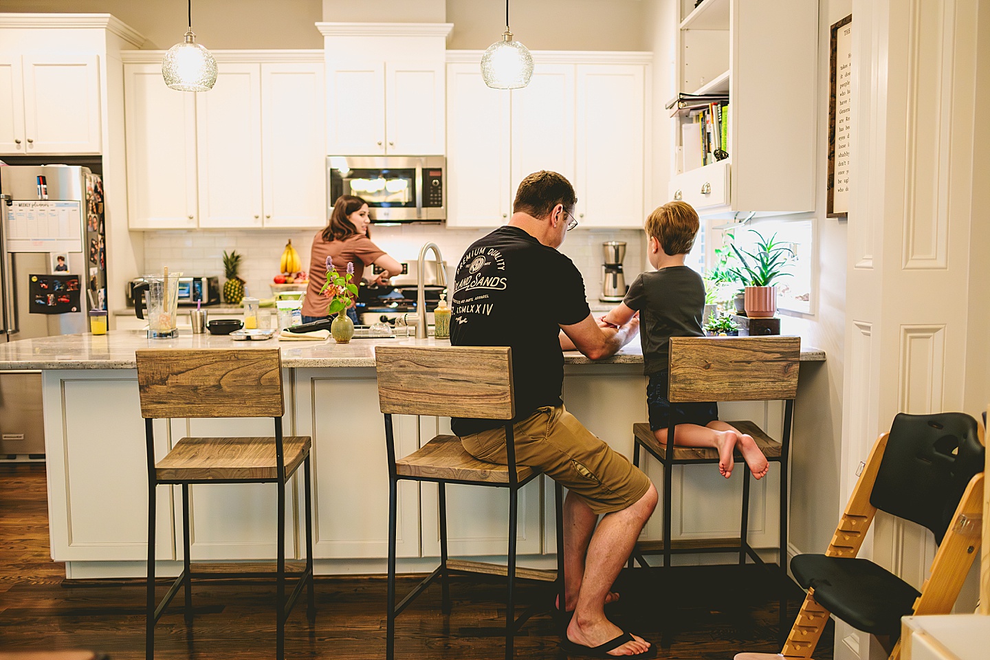 Toddler sitting at kitchen counter with his dad