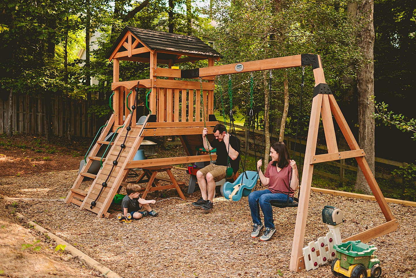 Family using family playground in backyard