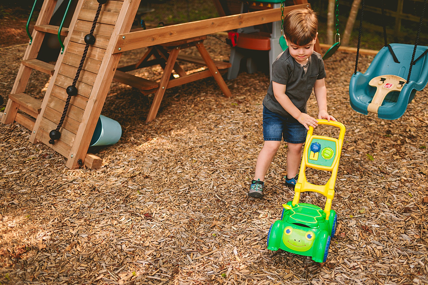 Kid pushing a toy lawn mower