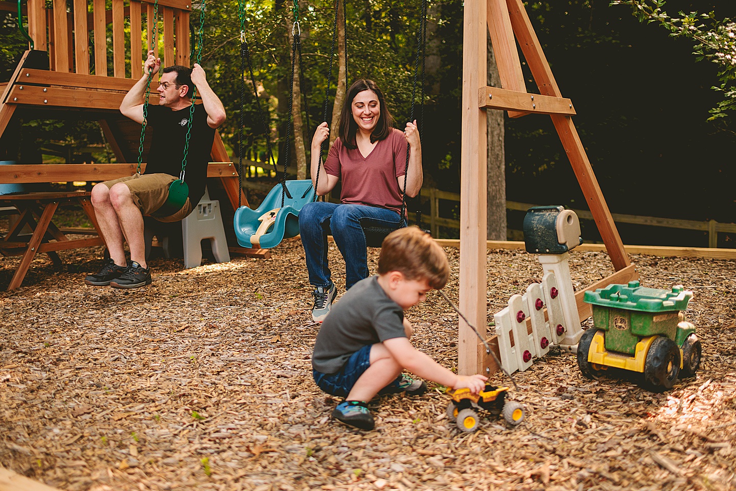 Family using family playground in backyard