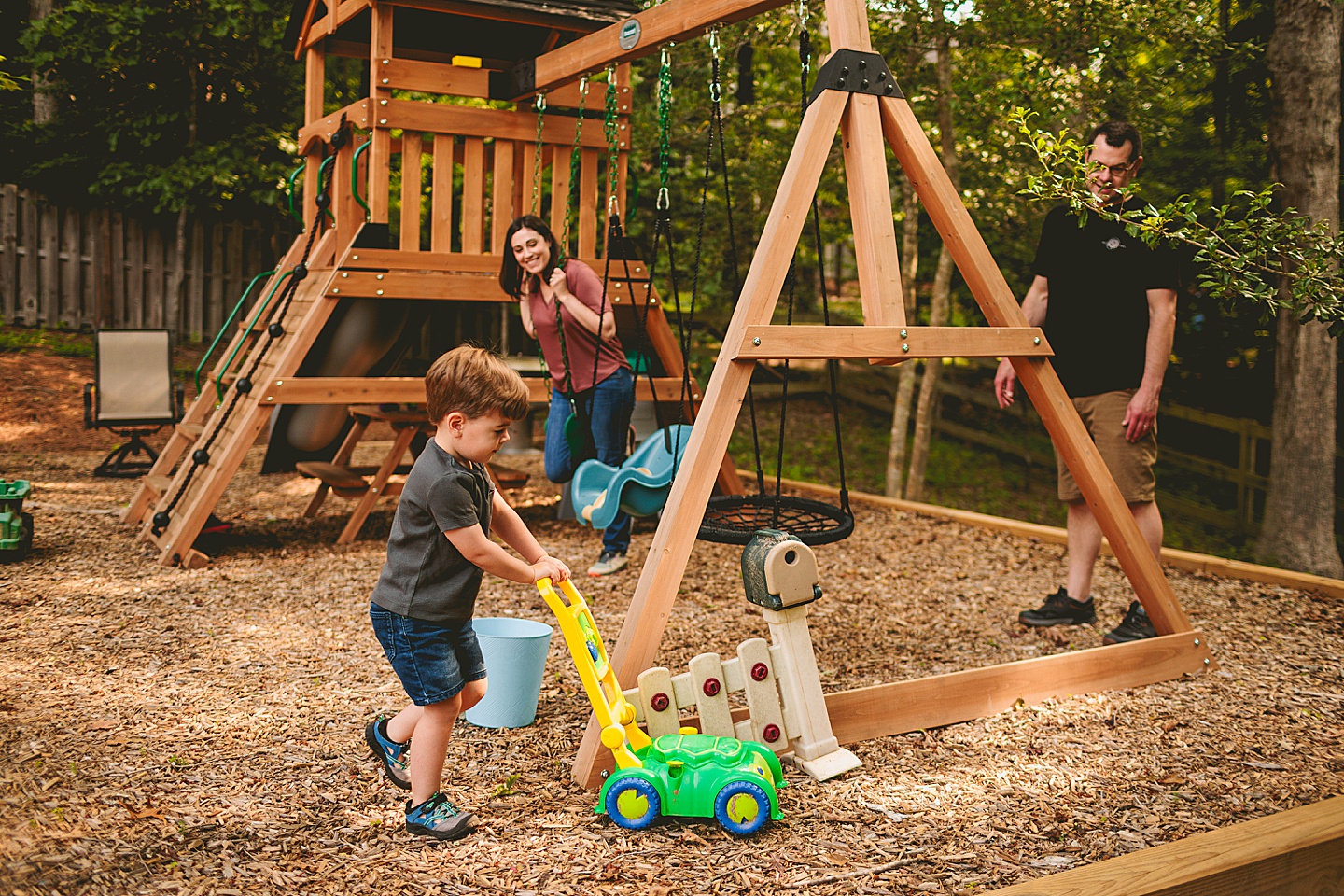 Family using family playground in backyard