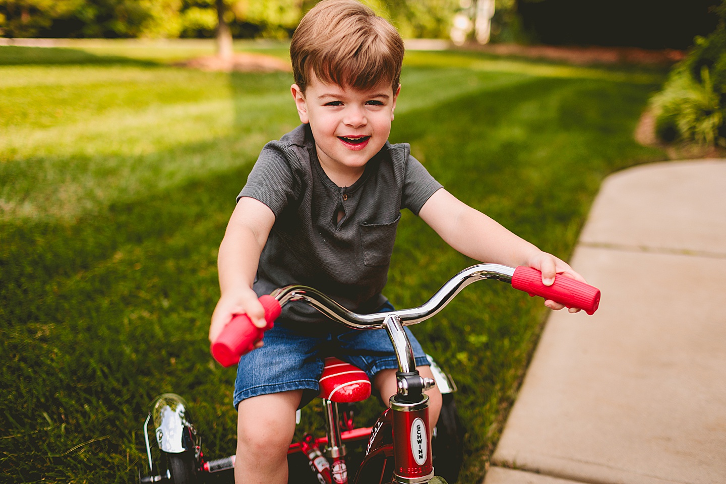 Child riding a tricycle through yard