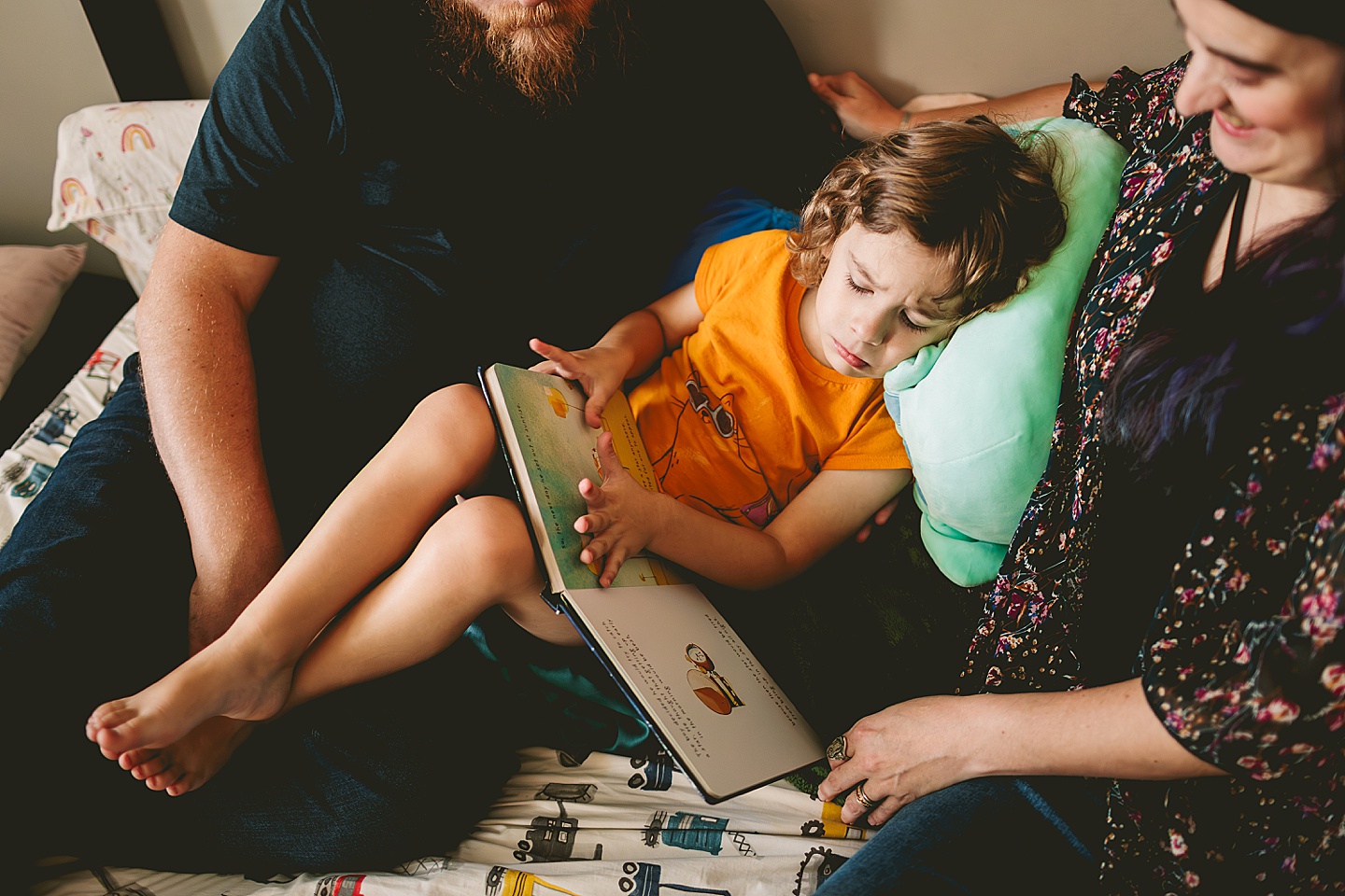 Parents reading to child in bed