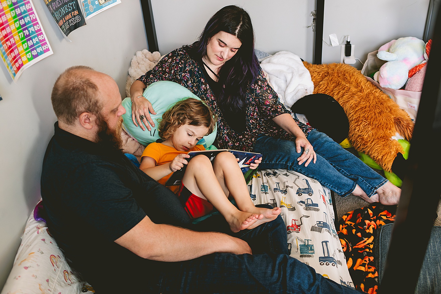 Parents reading to child in bed