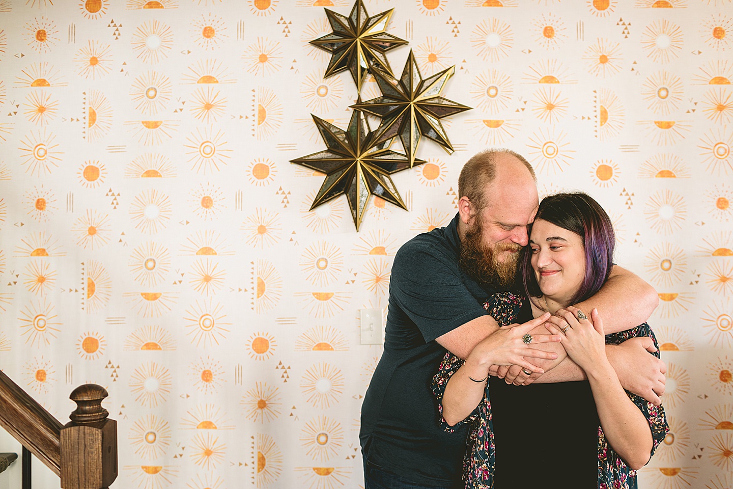 Portrait of a couple by a wallpapered wall