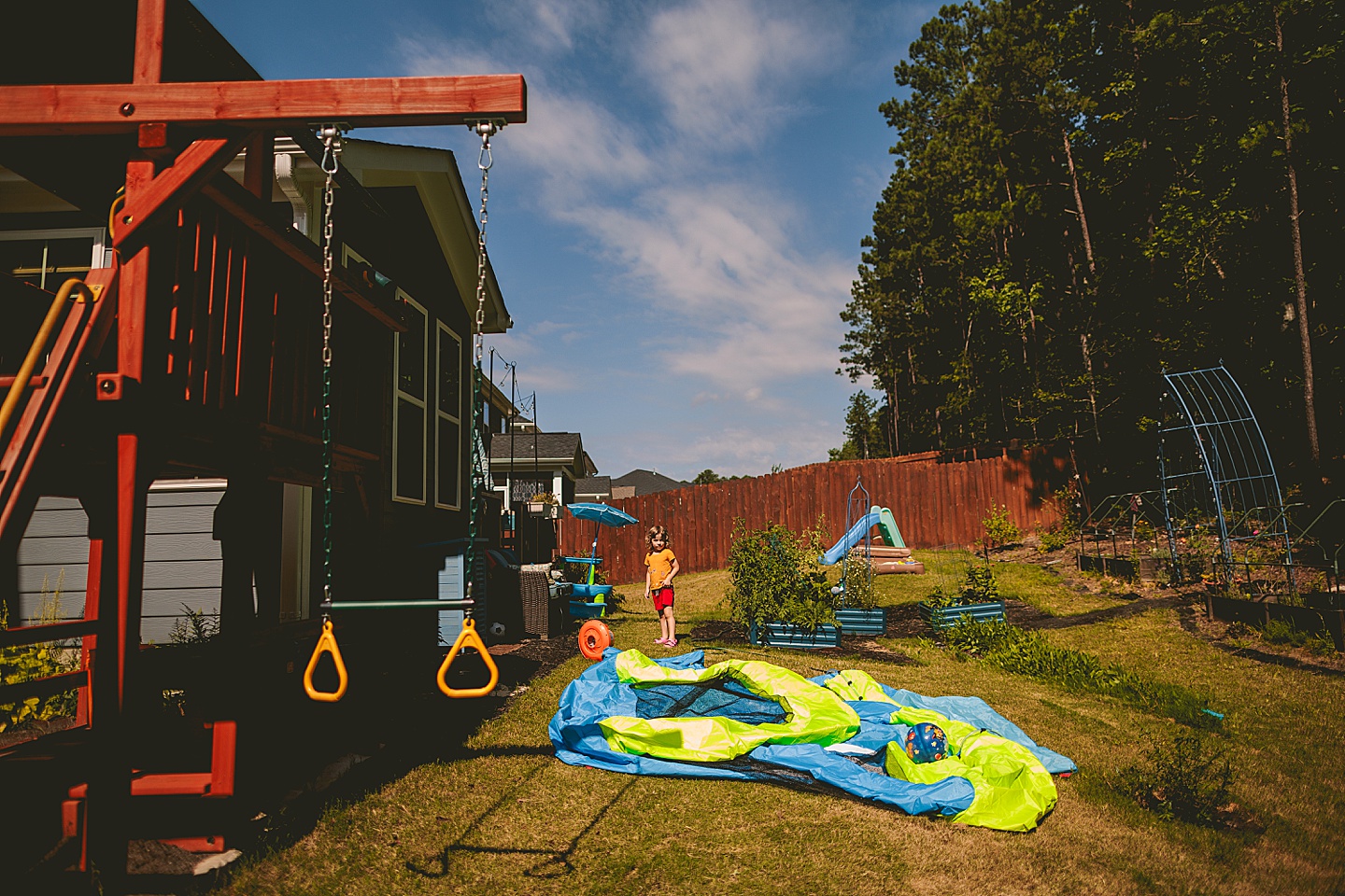 Boy jumping on deflated bounce house in backyard