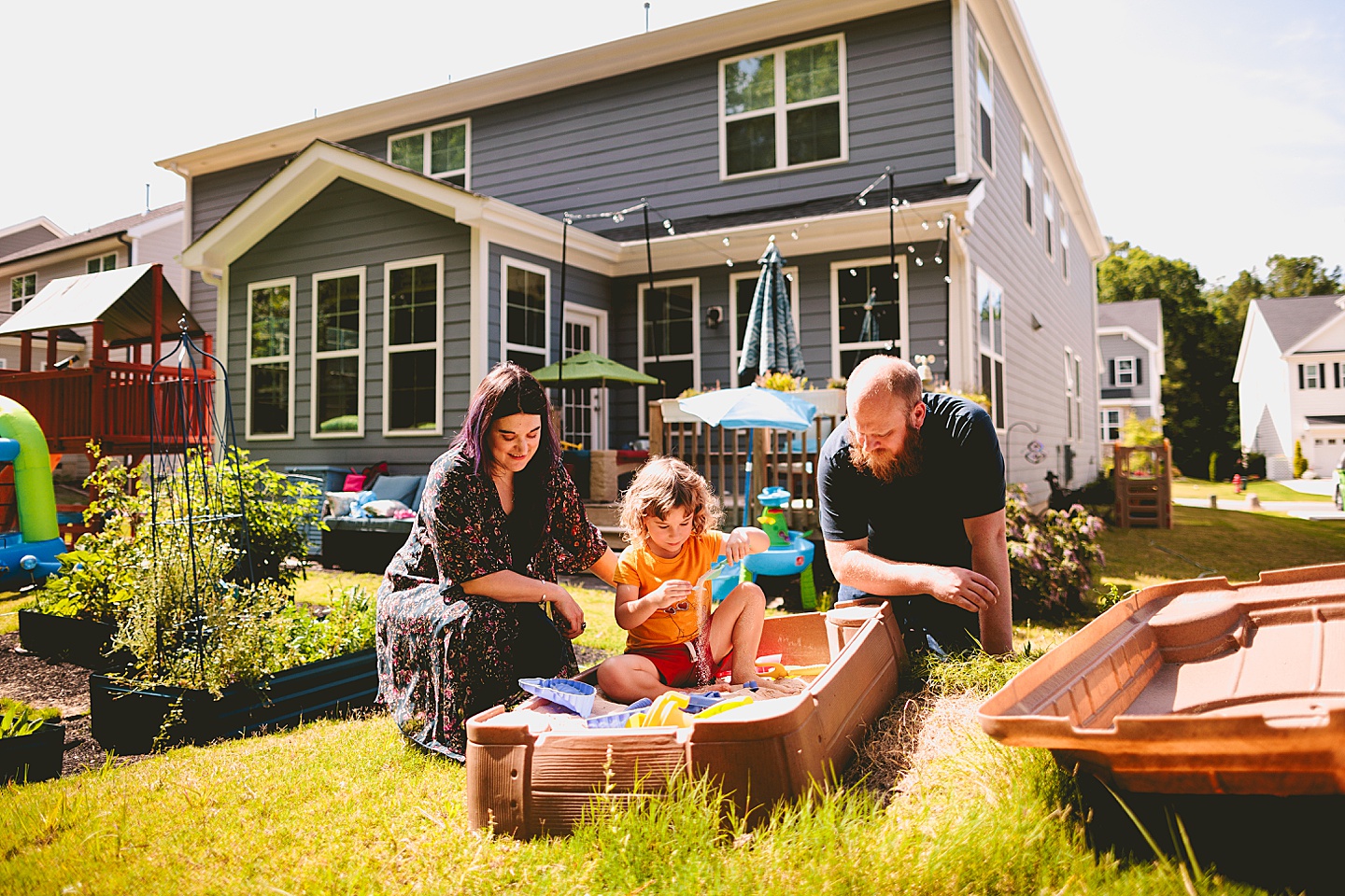 Child playing in sandbox in backyard