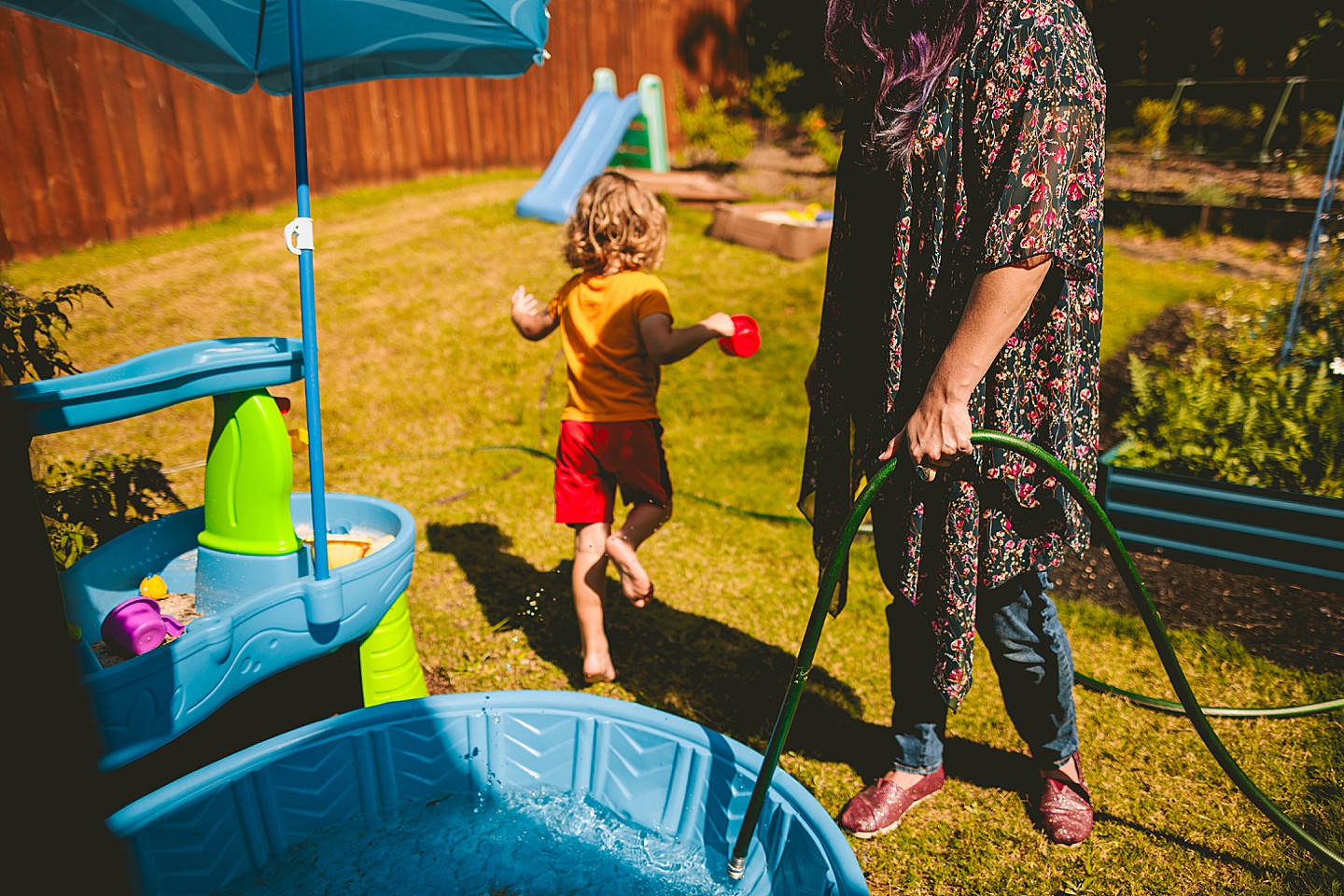 Child pouring sand into a swimming pool