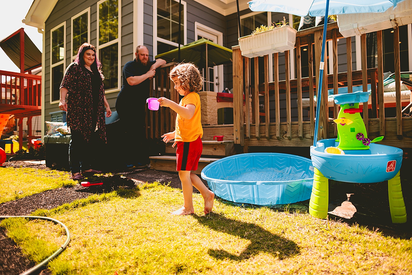 Child pouring sand into a swimming pool