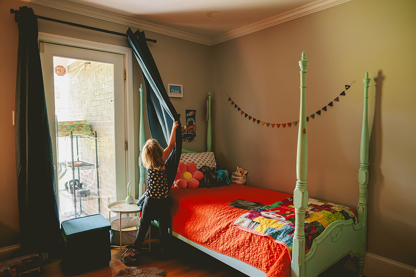 Kid opening curtains in window