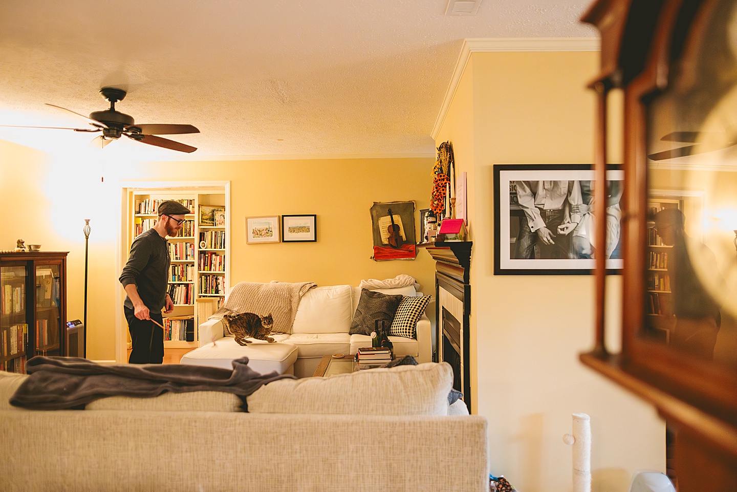 Guy playing with a toy wand for cat