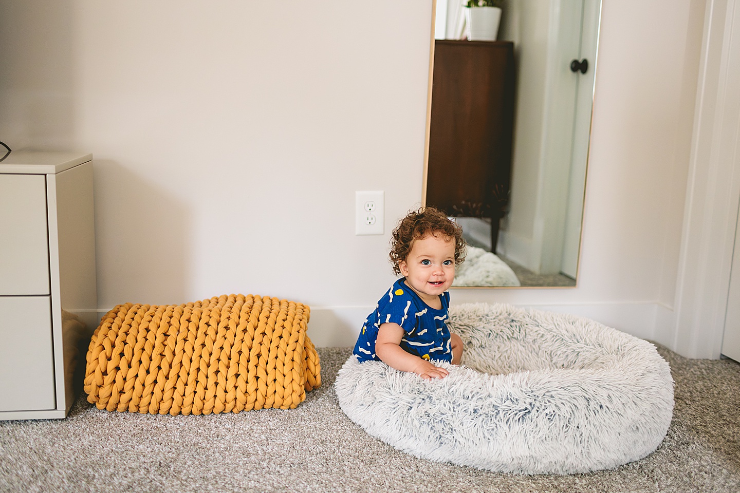 Toddler sitting in dog bed