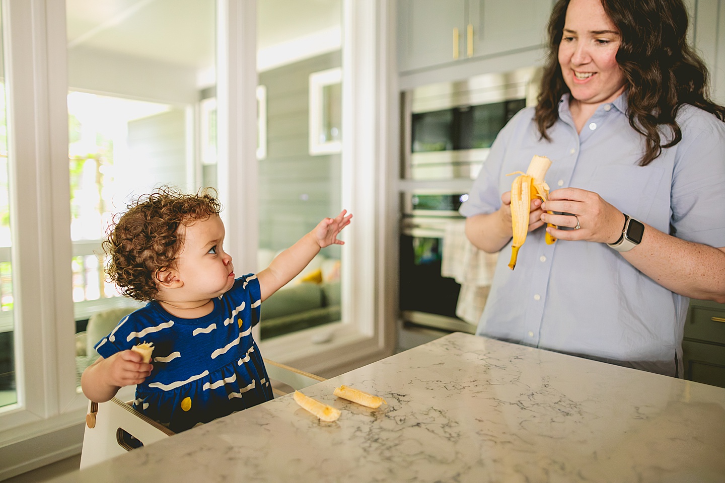 Mom feeding bananas to baby as lunch snack