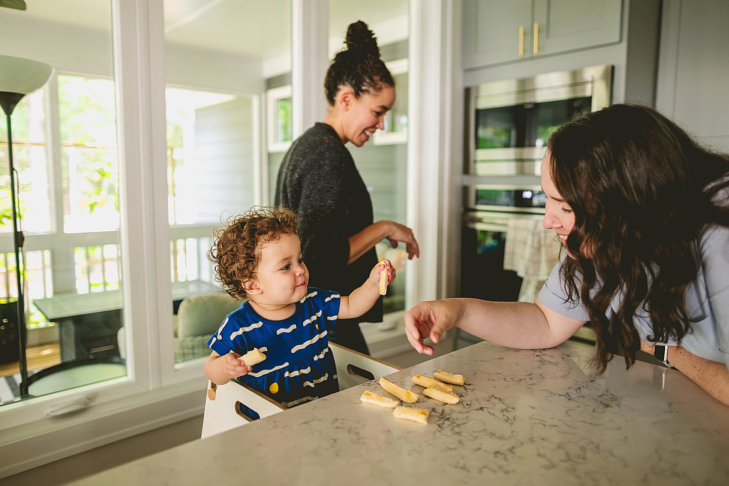 Mom feeding bananas to baby as lunch snack