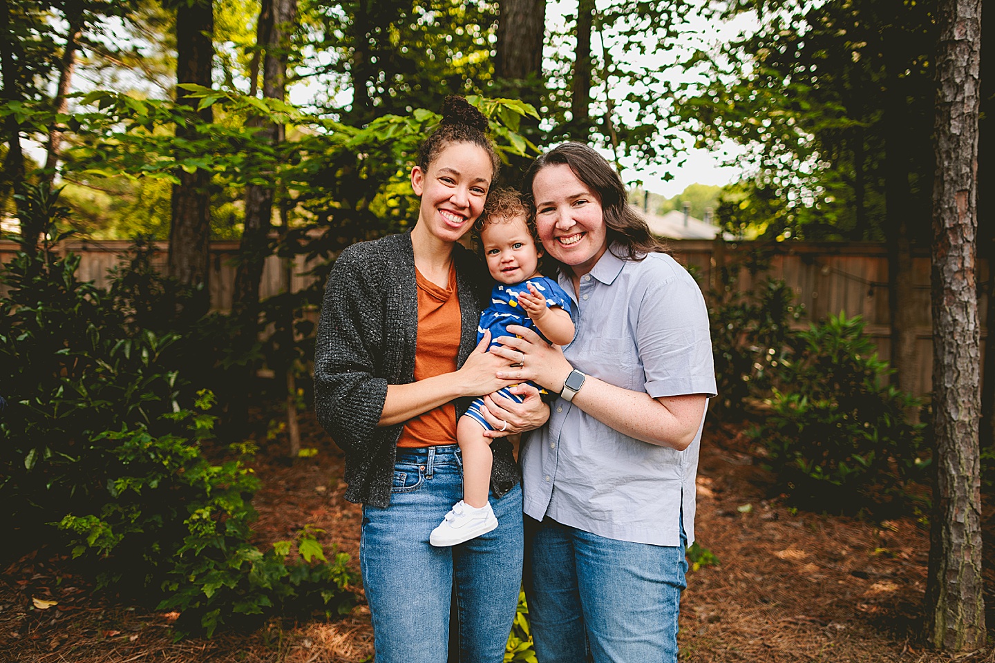 Moms holding baby daughter in family portrait