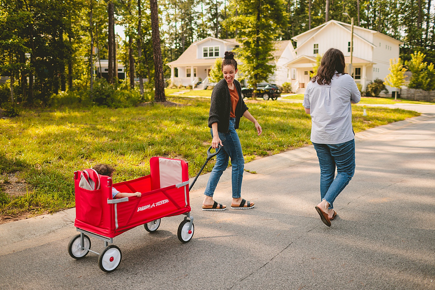 Baby riding in red wagon