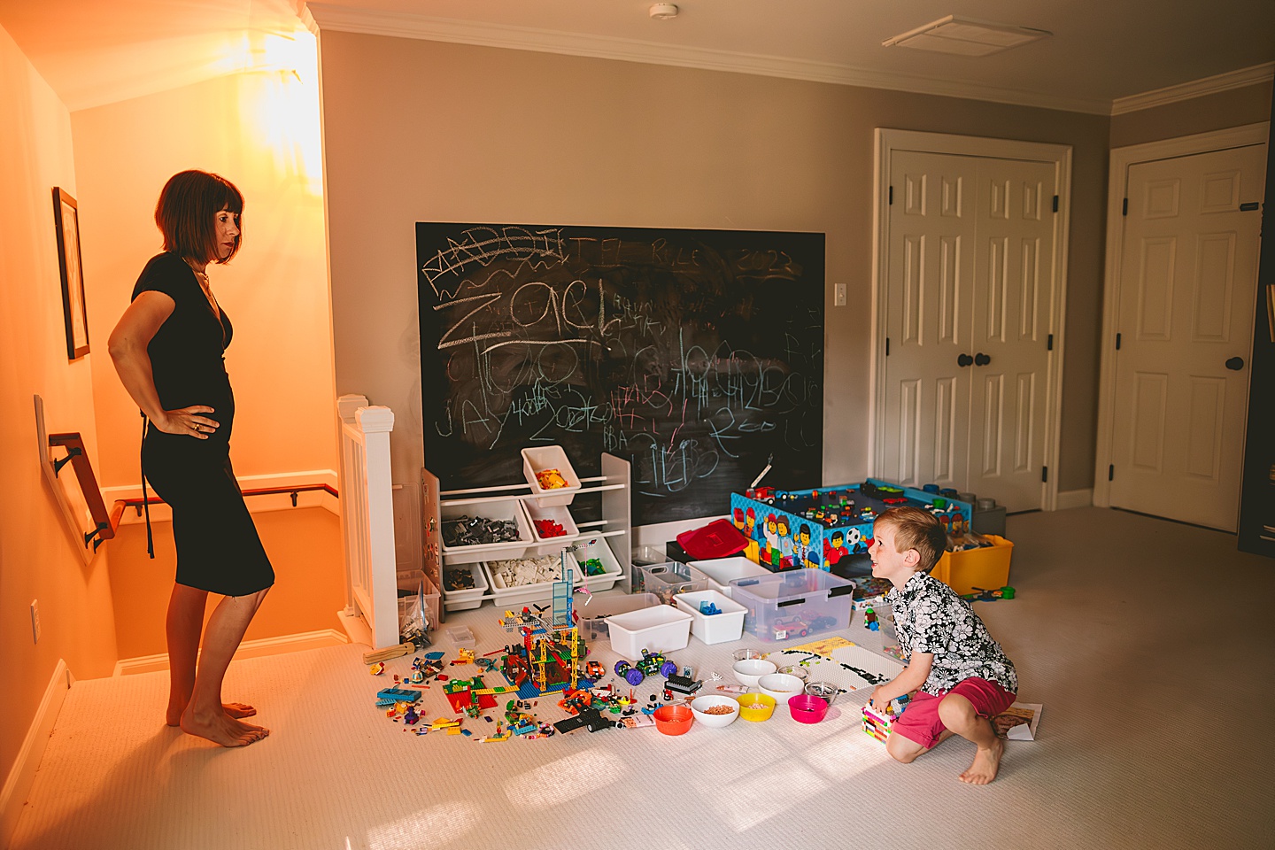 Kid playing with Legos while talking to his mom