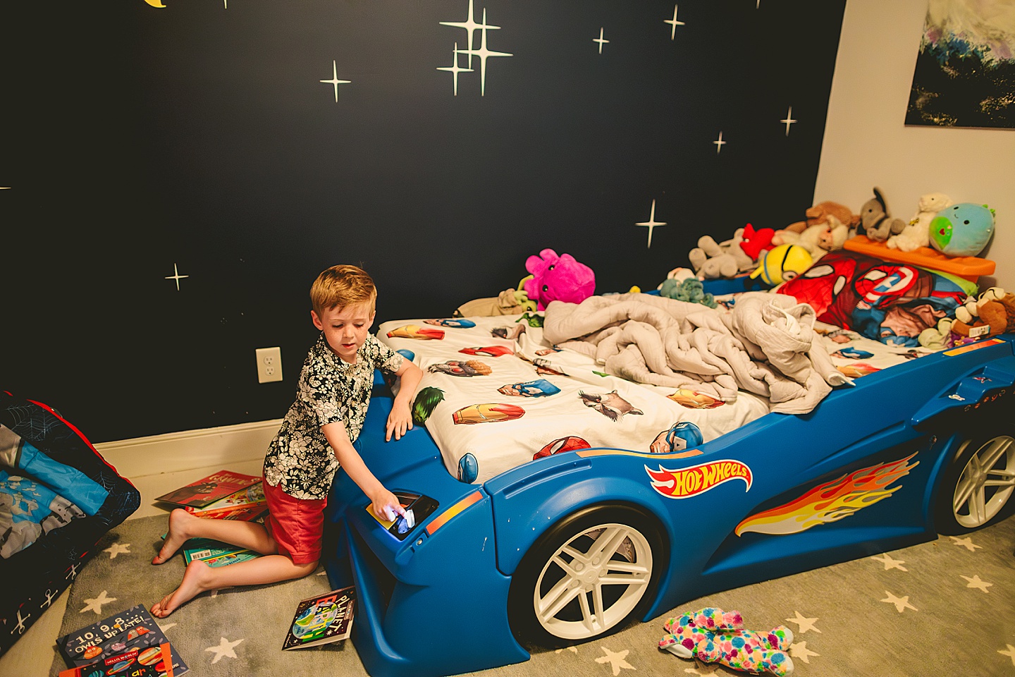 Kid hanging out in bedroom with race car bed