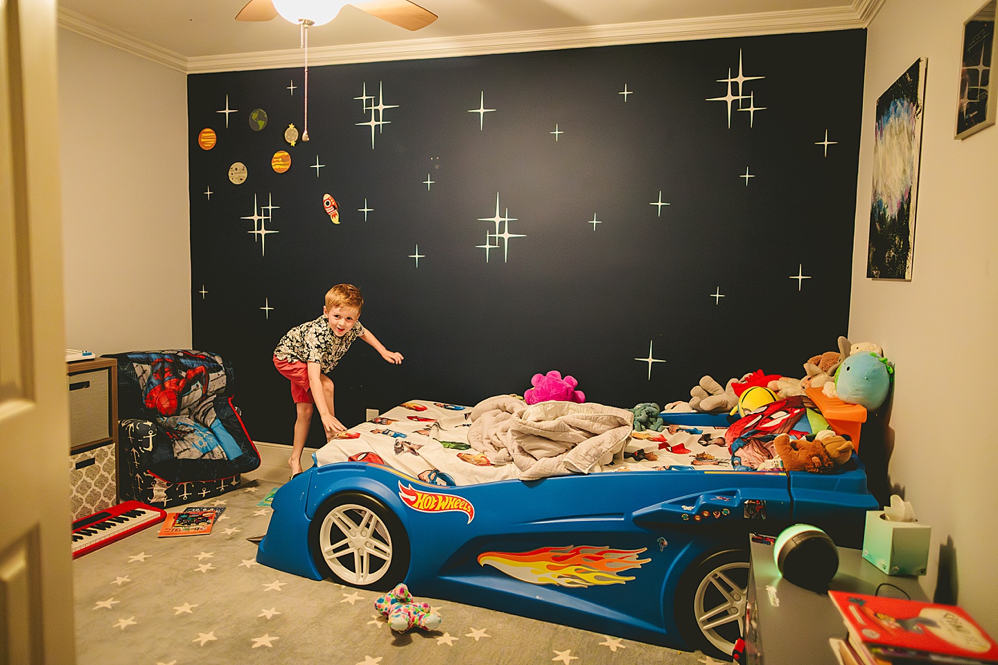 Kid hanging out in bedroom with race car bed