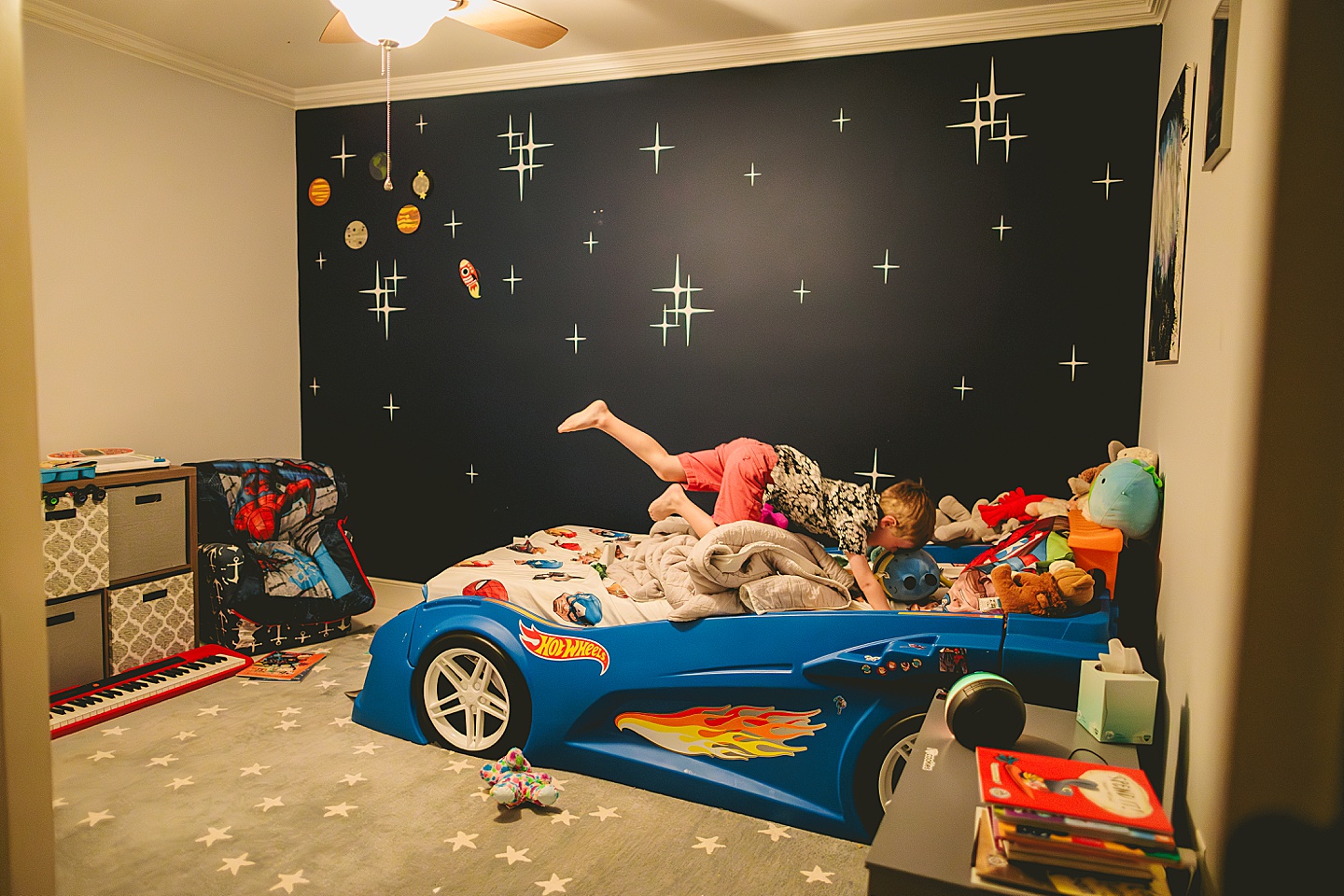 Kid jumping on race car bed