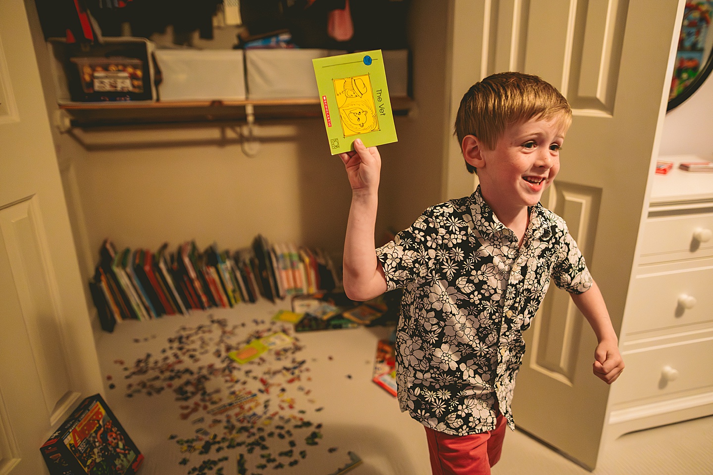 Boy running out of his closet holding a book