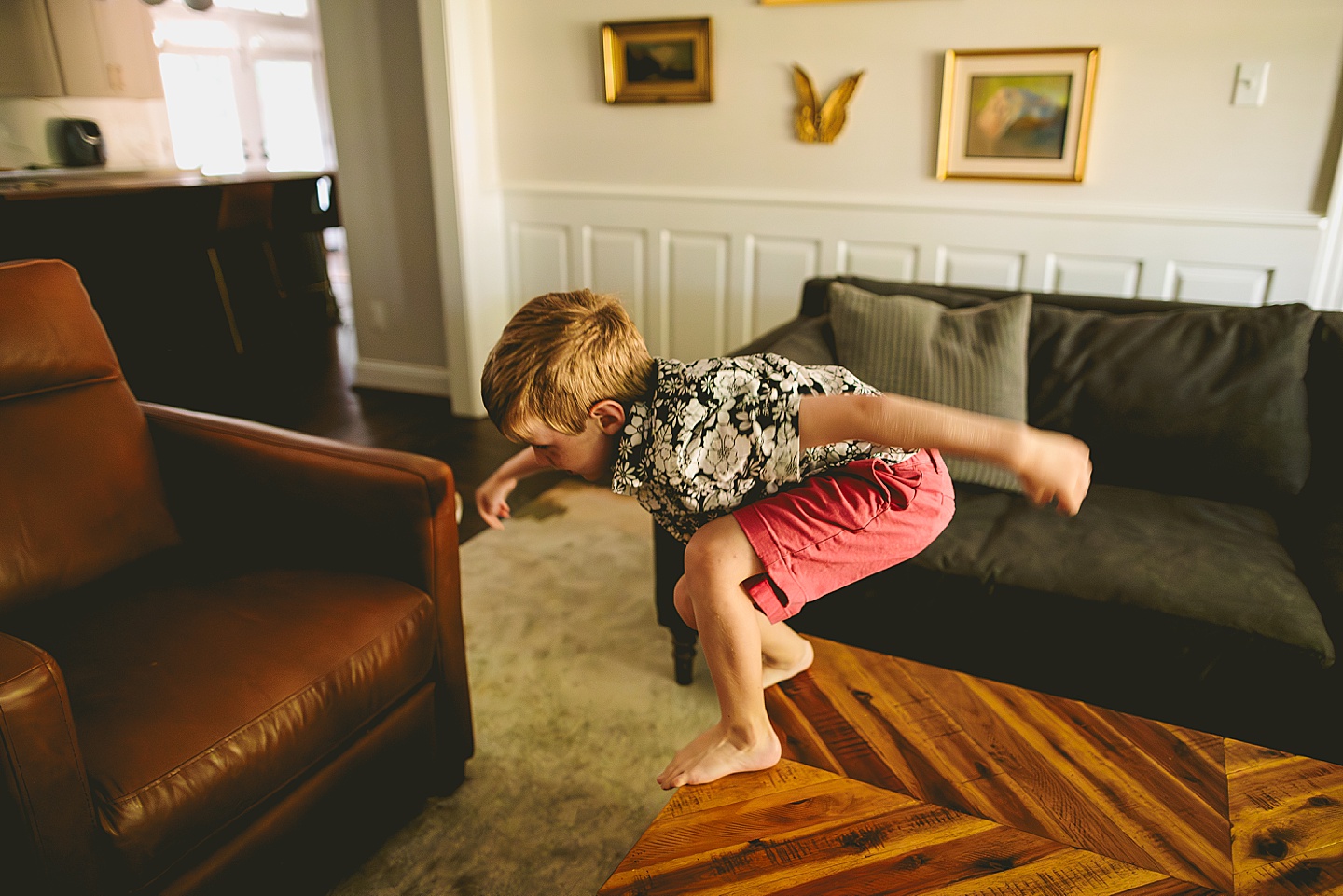Boy jumping on living room furniture