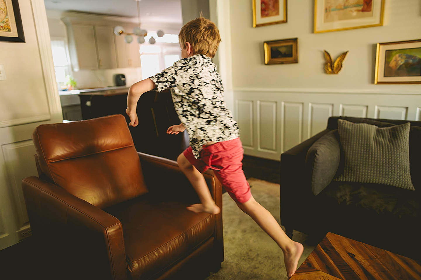 Boy jumping on living room furniture