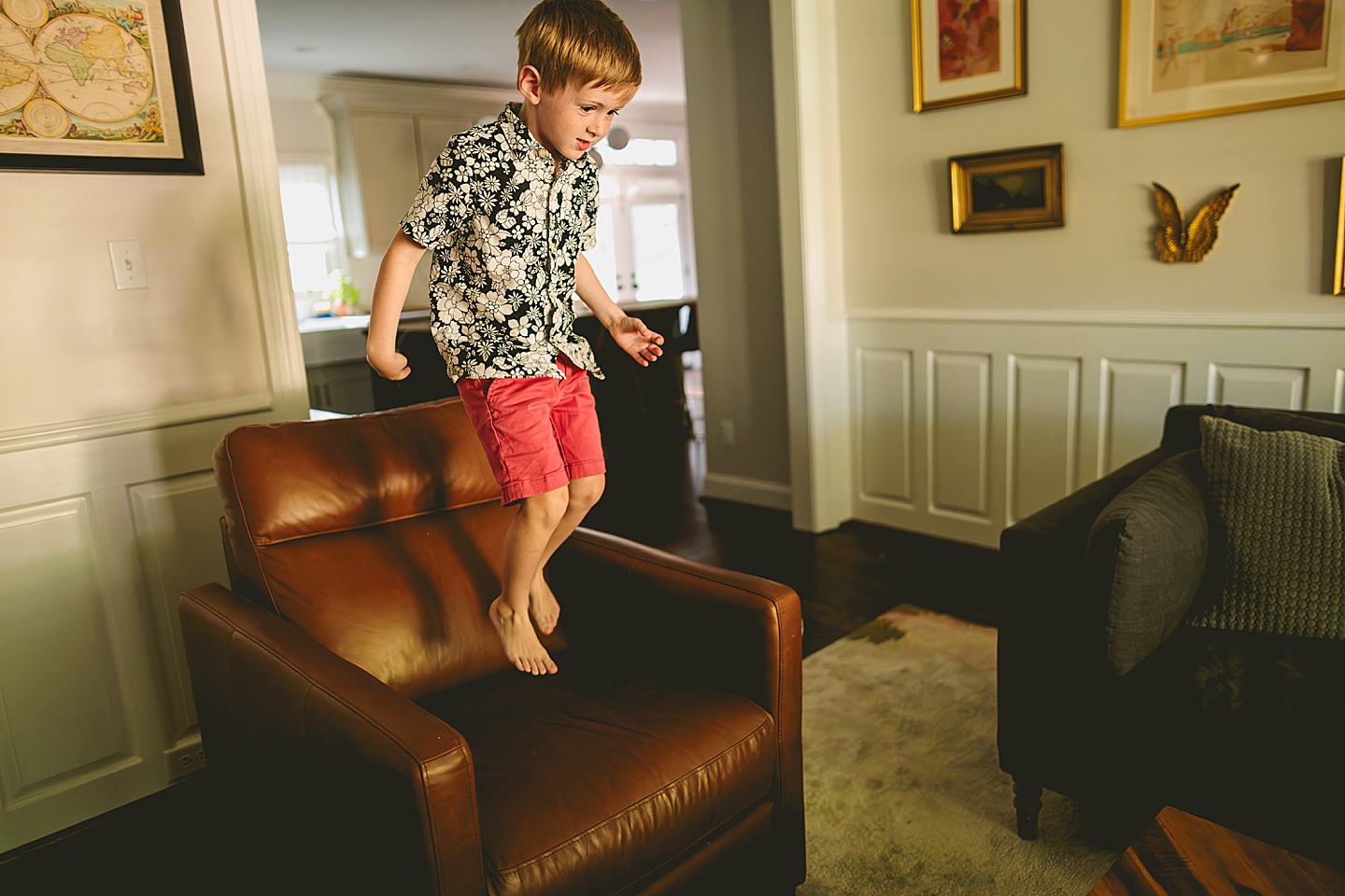 Boy jumping on living room furniture