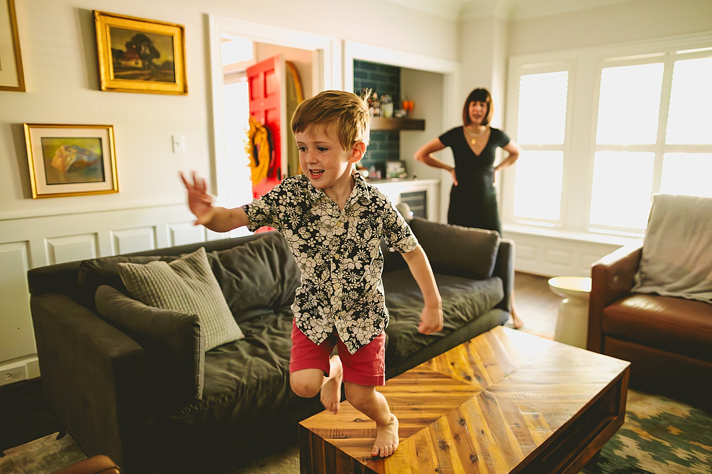 Boy jumping on living room furniture