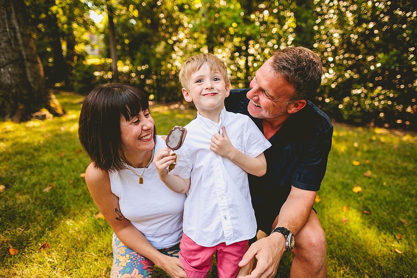 Boy eats popsicle with parents outside in Raleigh