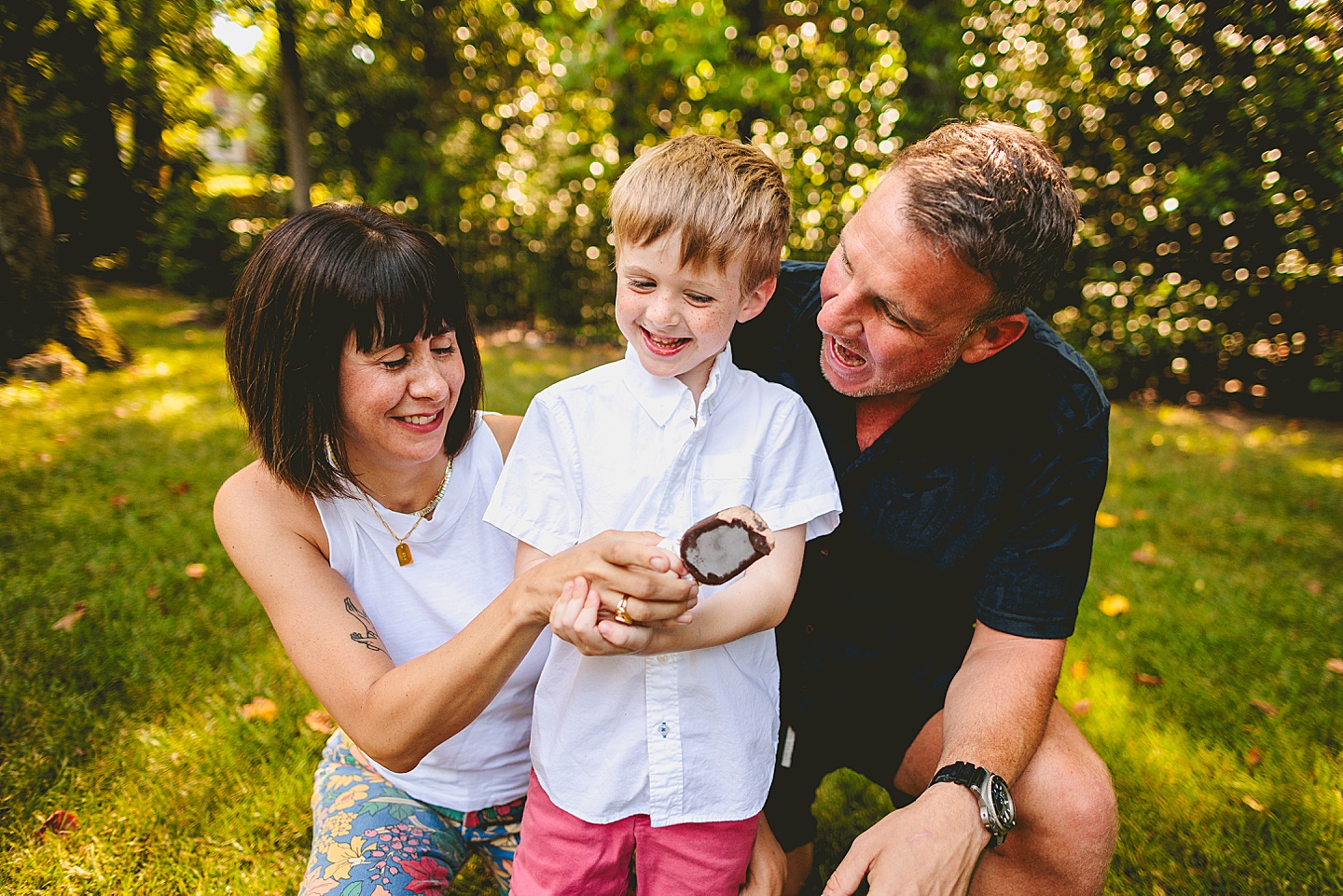 Boy eats popsicle with parents outside in Raleigh