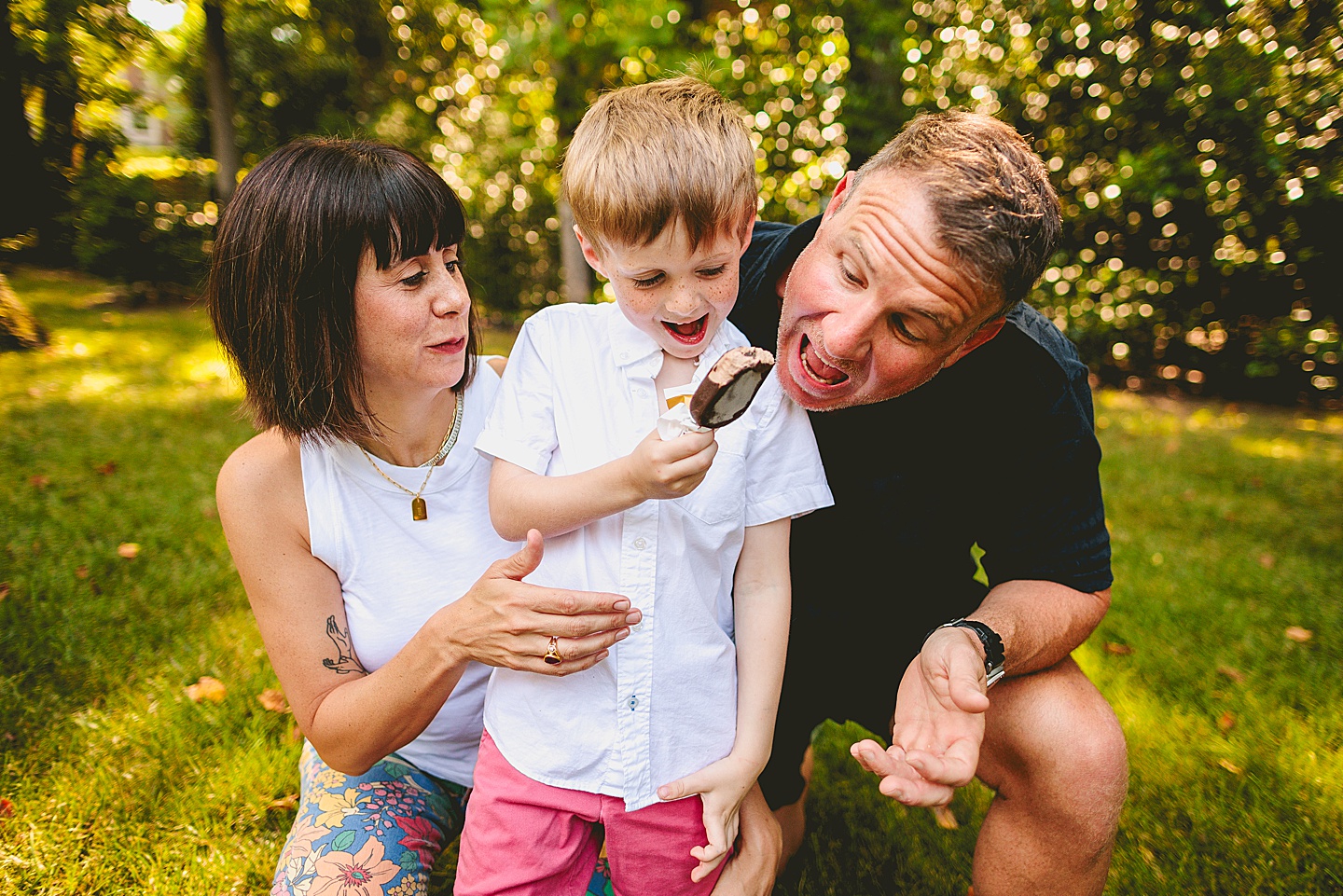 Boy eats popsicle with parents outside in Raleigh