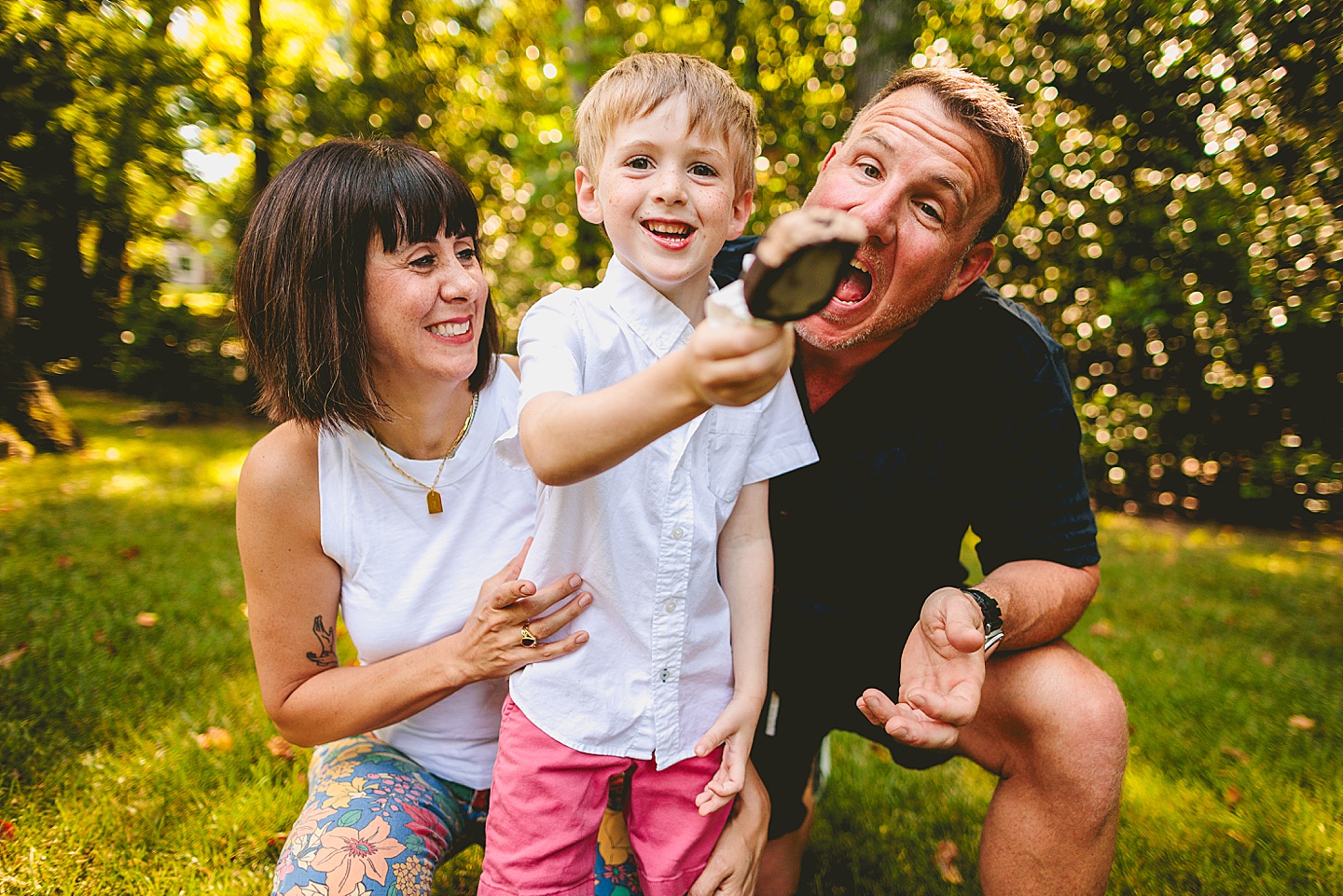 Boy eats popsicle with parents outside in Raleigh