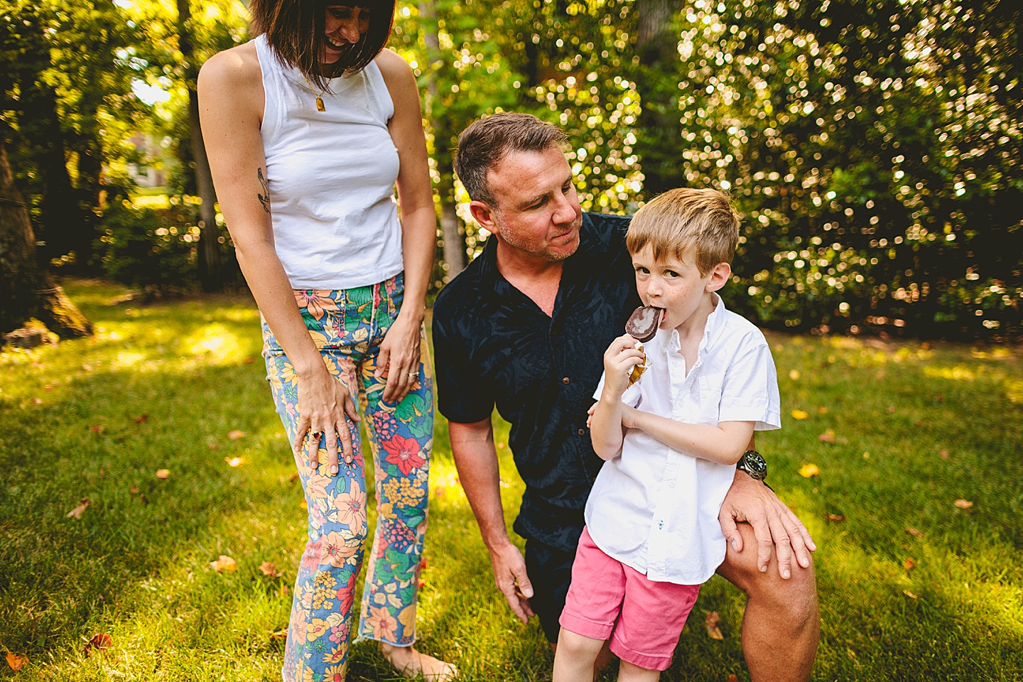 Boy eats popsicle with parents outside in Raleigh