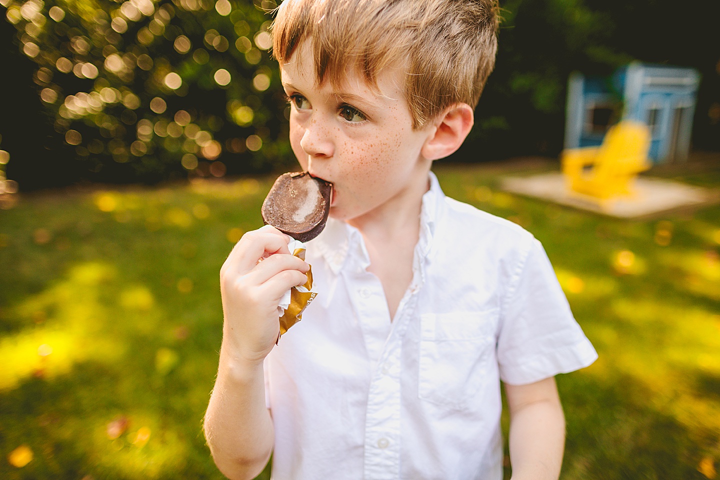 Boy eats popsicle with parents outside in Raleigh