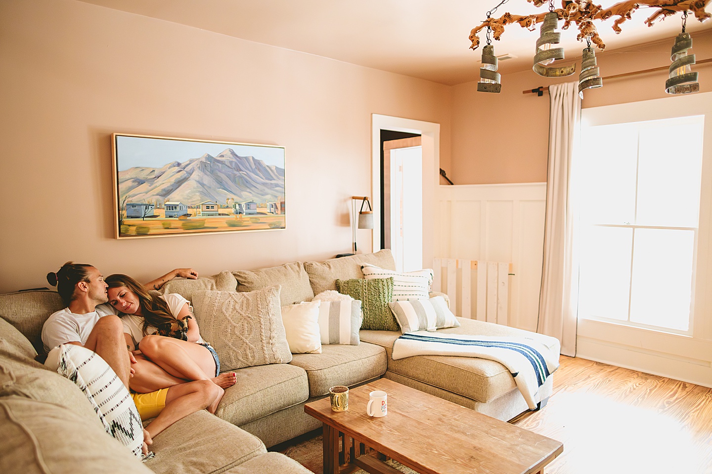 Couple sitting on their couch holding their small dog